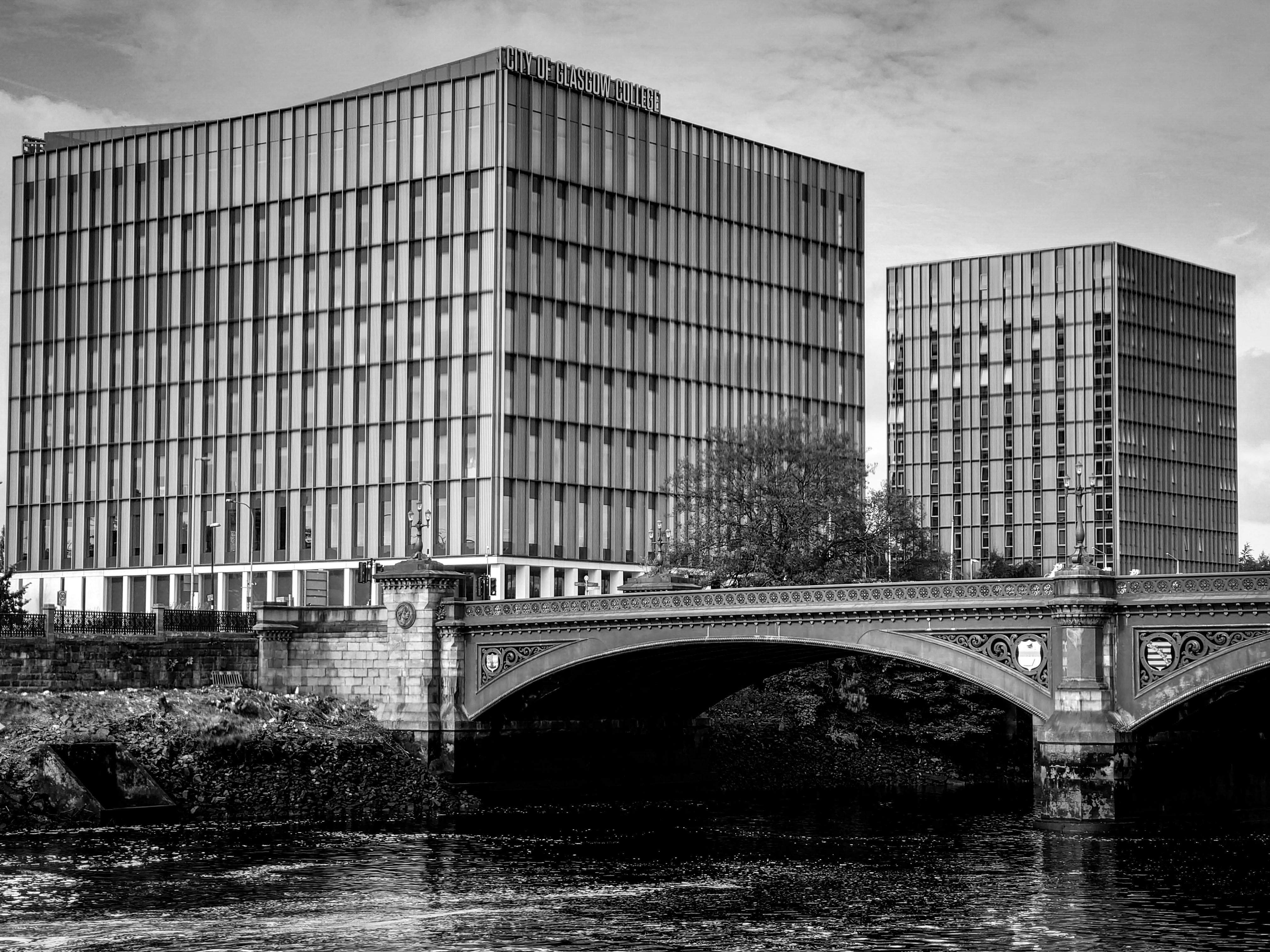 black and white photo of a bridge over water