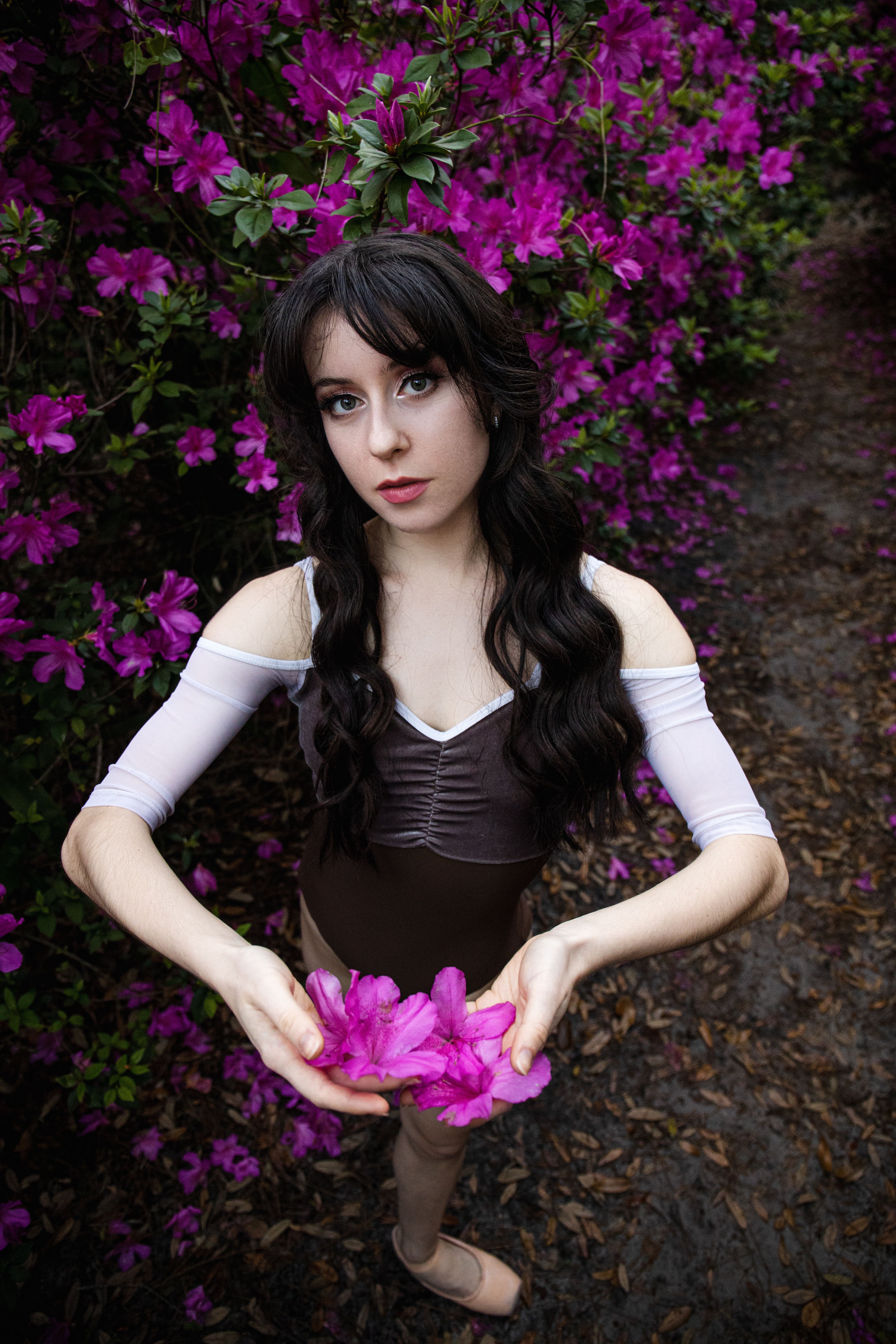 A girl in a black dress holding flowers · Free Stock Photo