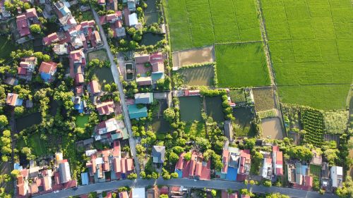 Free Captivating aerial shot of a lush Vietnamese village and rice fields. Stock Photo