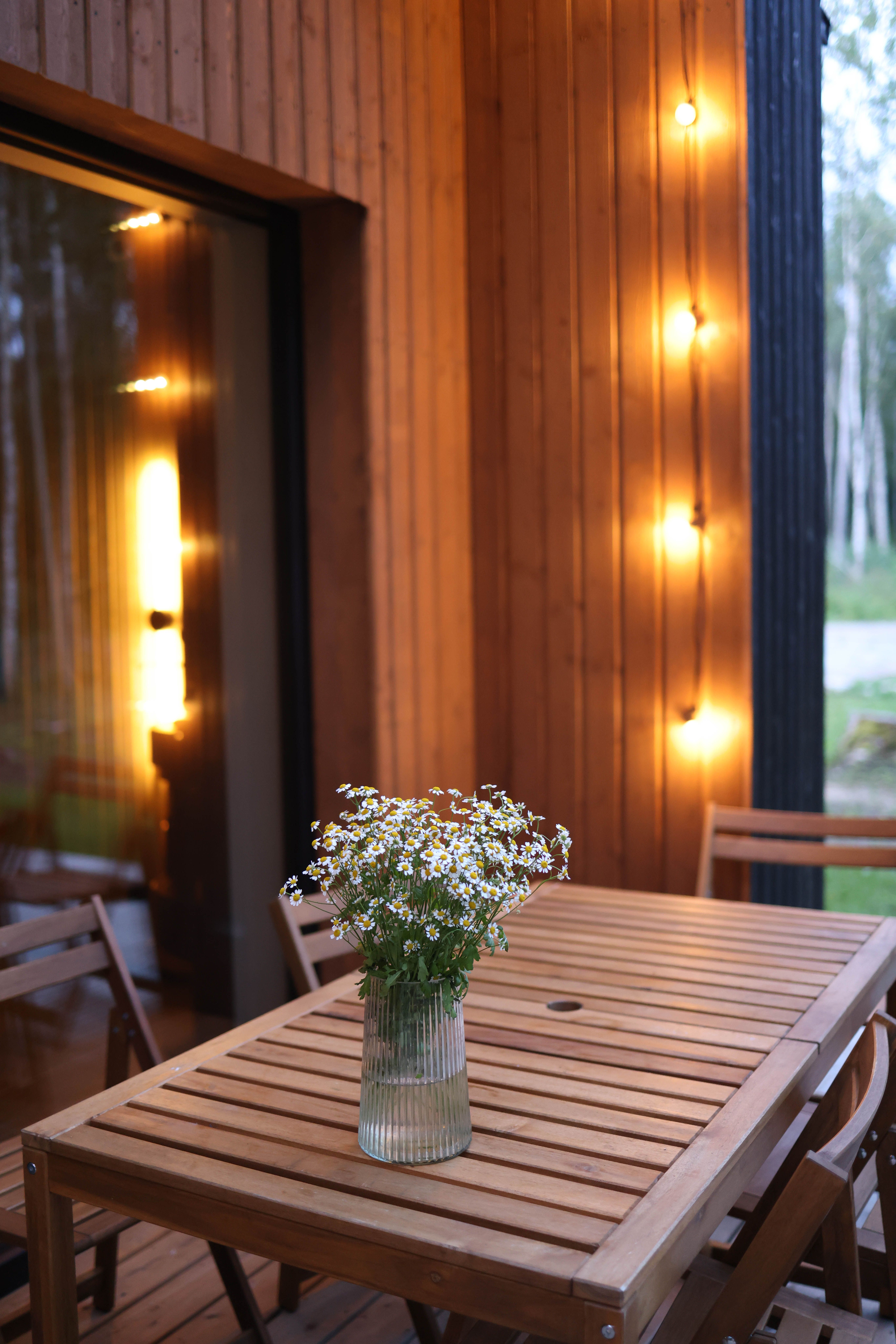 Warm outdoor patio setting featuring wooden furniture and soft ambient lighting for a relaxing evening.
