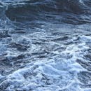 白天，温和的海浪被白色的泡沫海沫捕捉