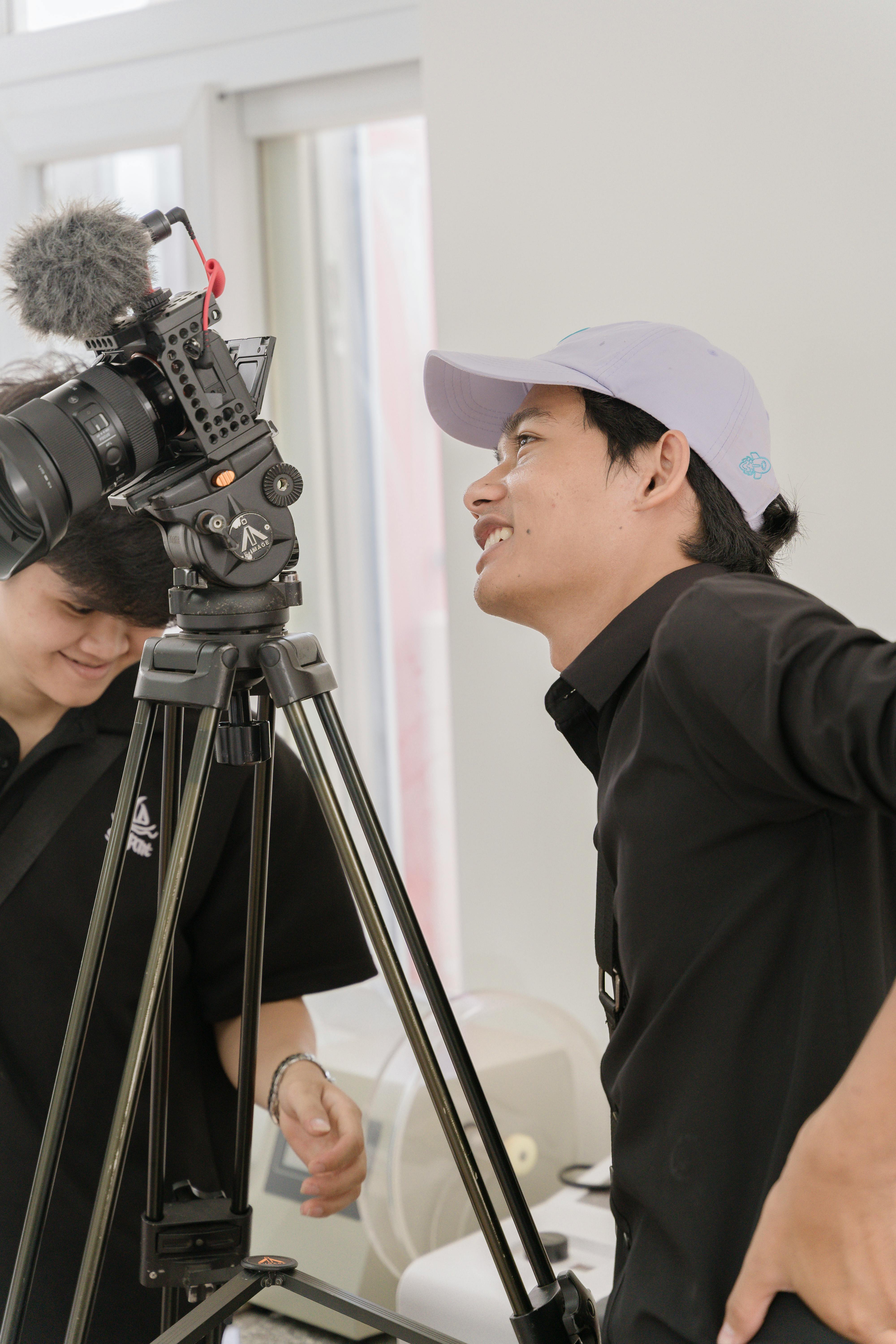 two people are standing next to a camera