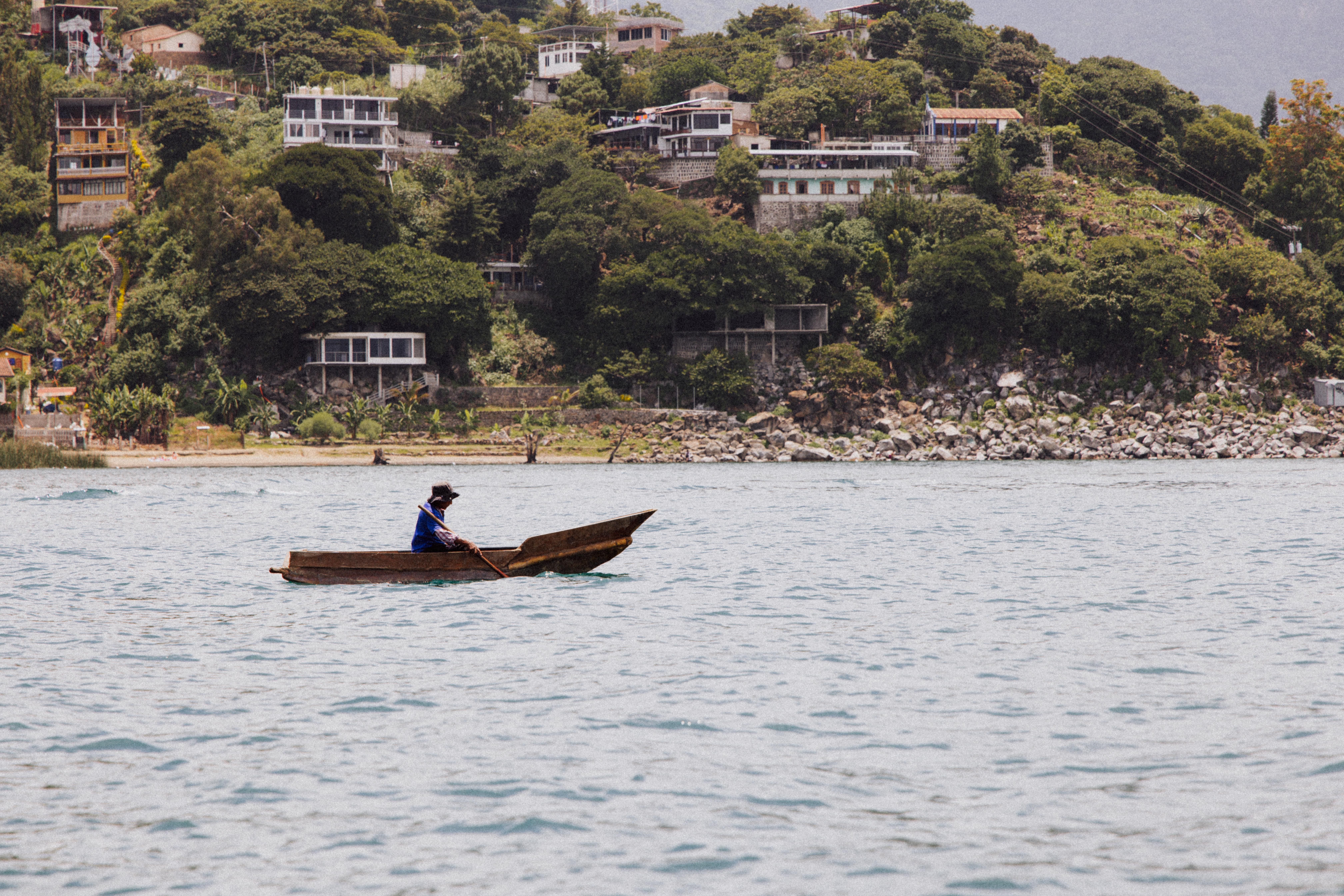 A man in a small boat on the water · Free Stock Photo