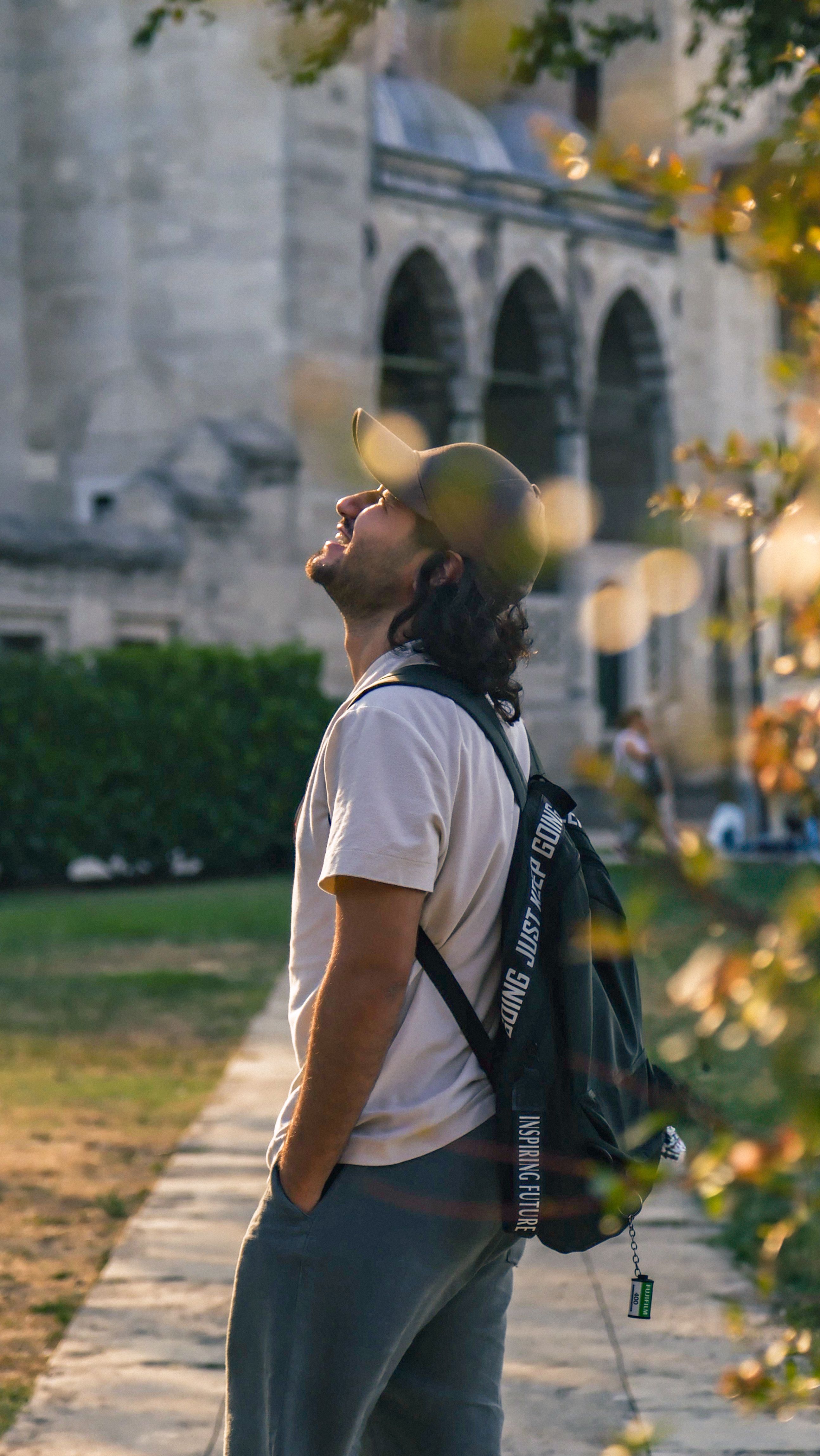 A man with a backpack is looking up