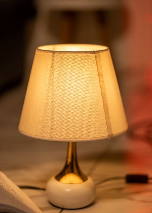 Free Warm, elegant table lamp casting a soft glow, perfect for adding a touch of luxury to any room. Stock Photo