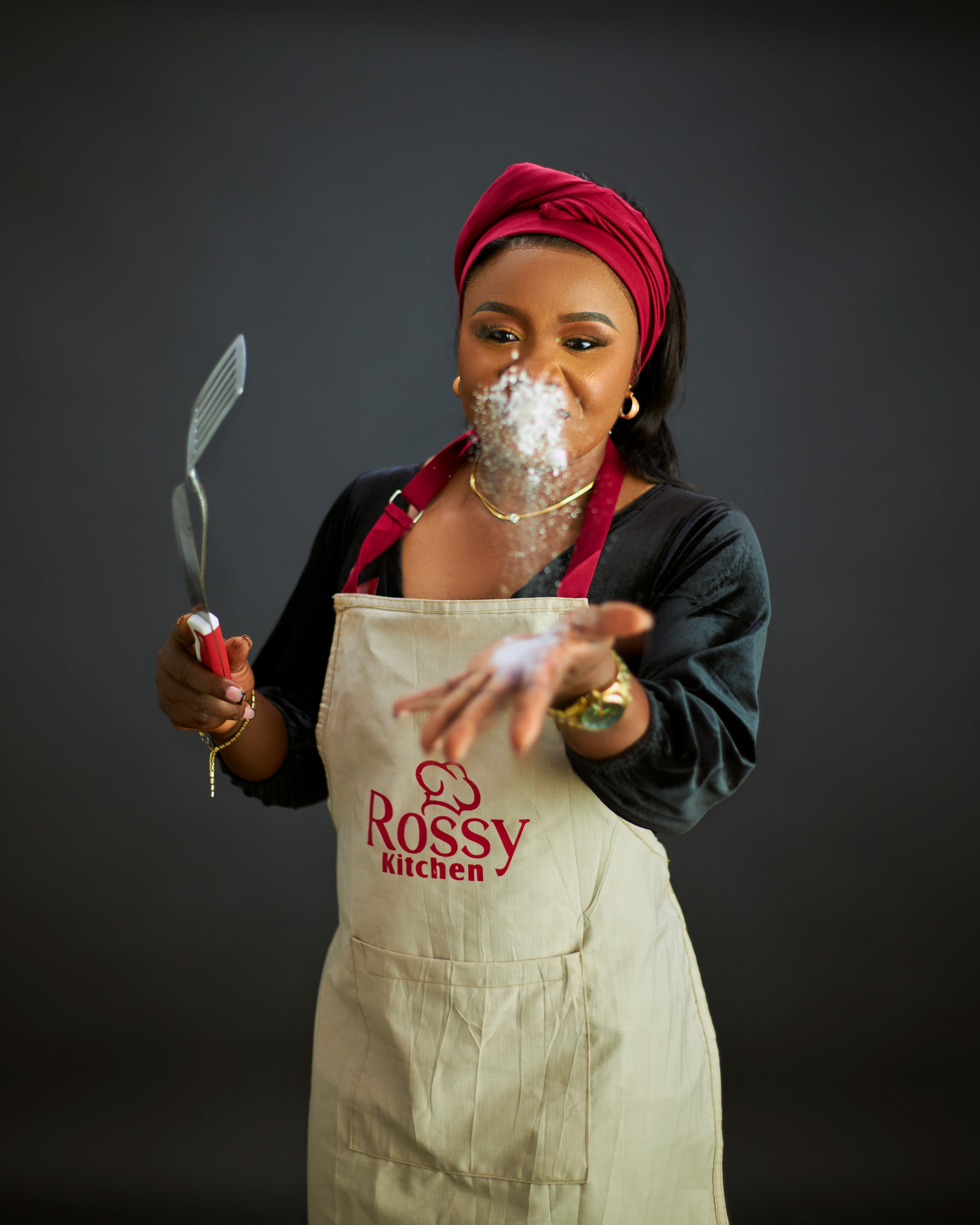 A cheerful woman chef having fun with flour in her kitchen.