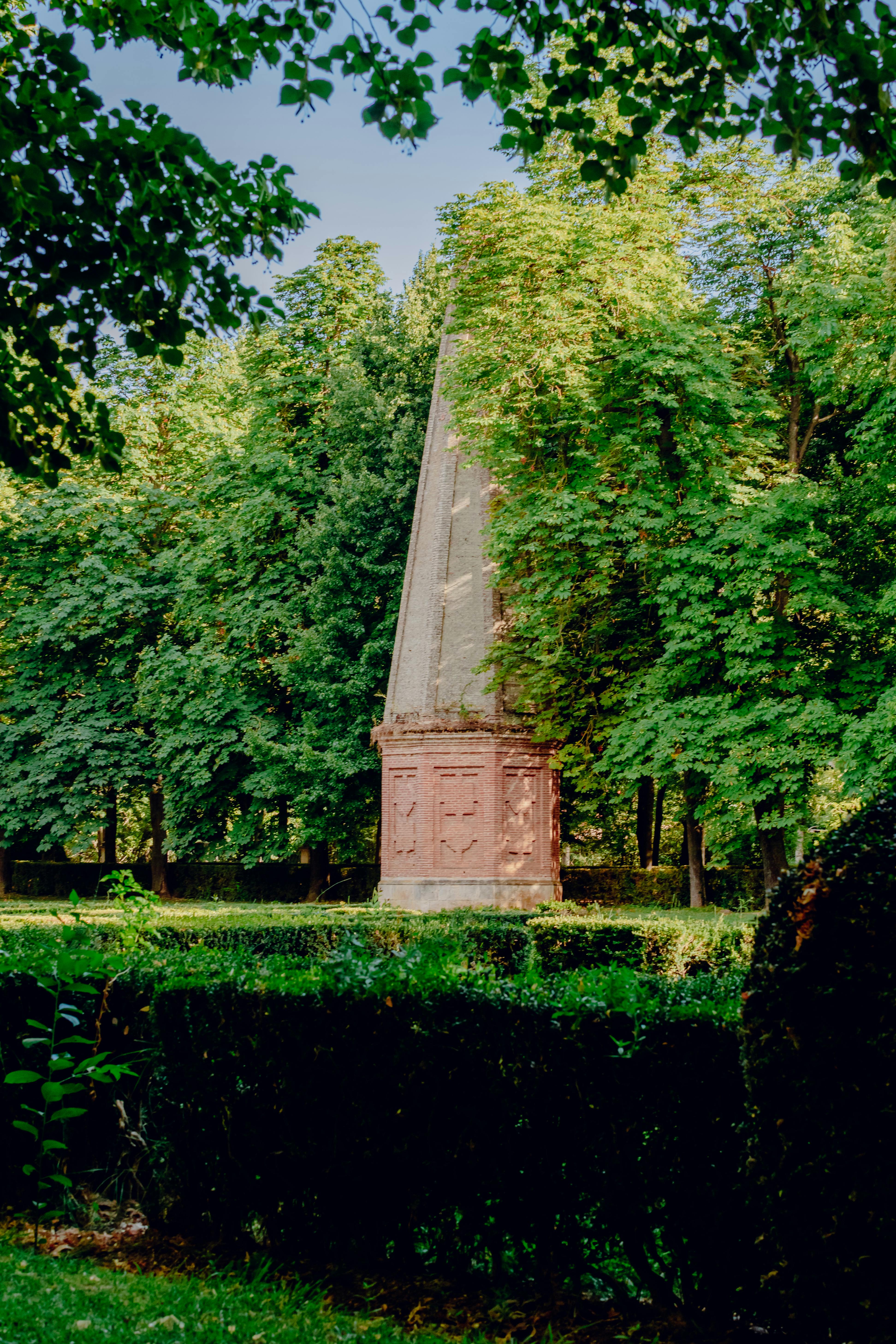 a monument in the middle of a park surrounded by trees