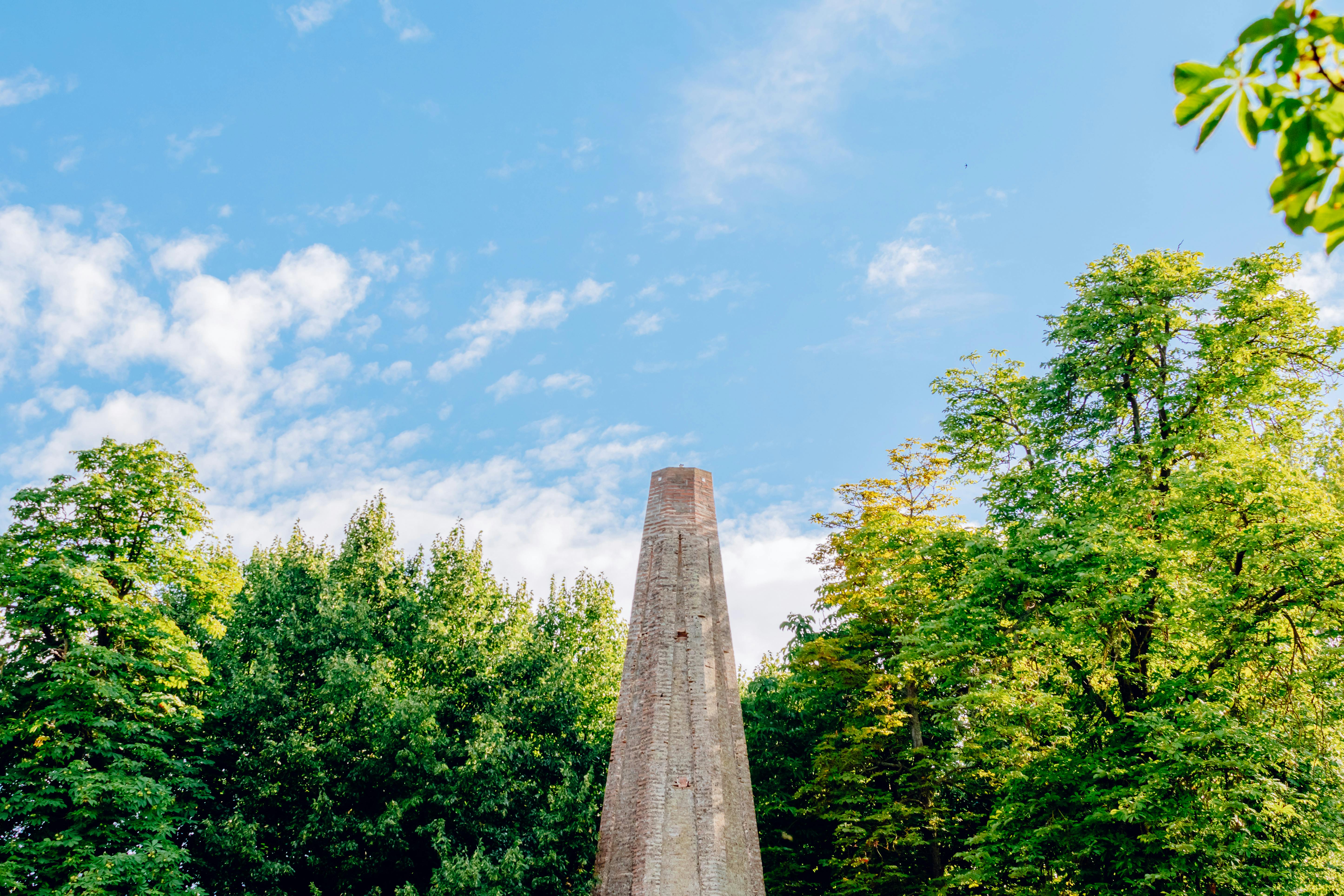 a monument in the middle of a park with trees