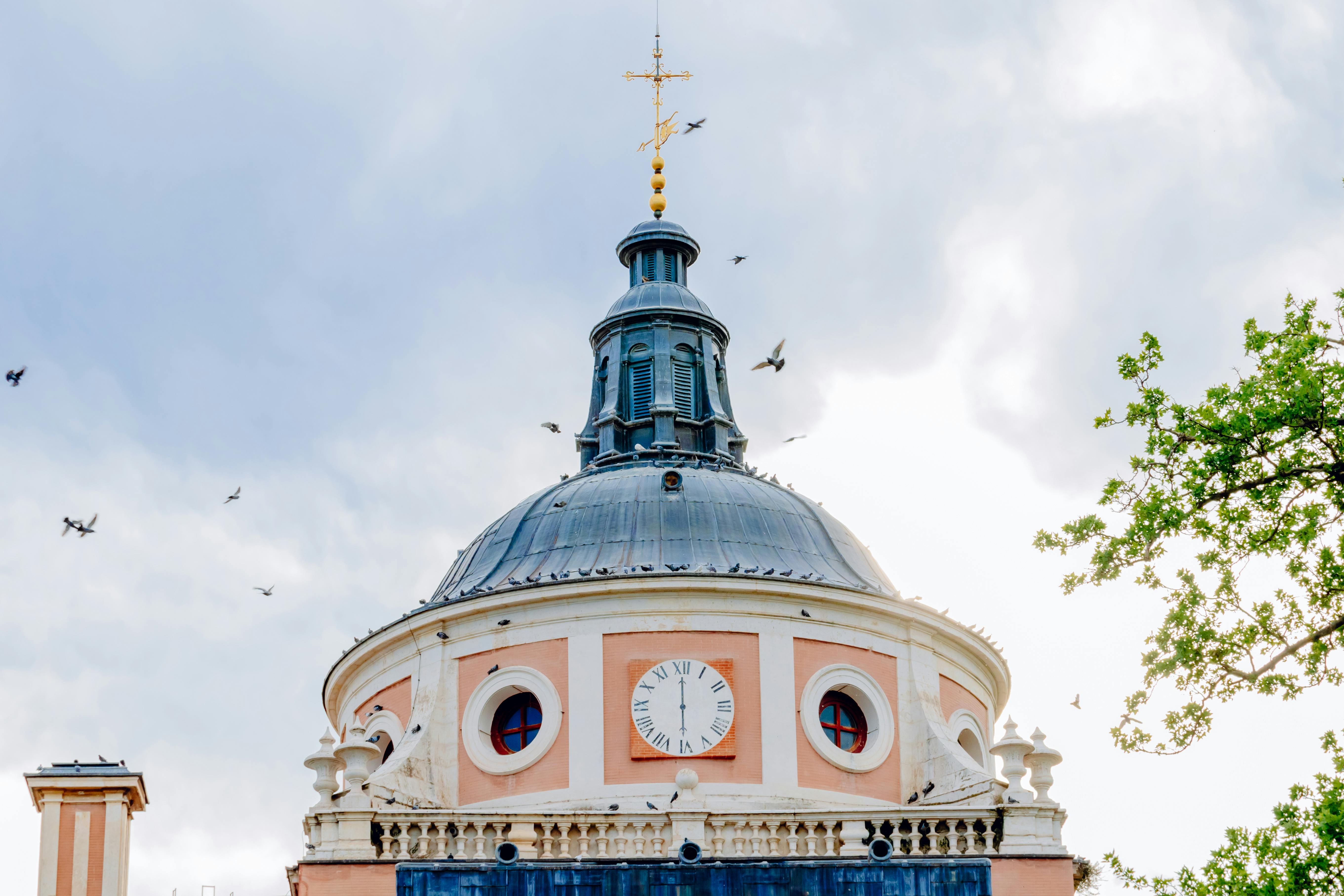 a building with a dome and birds flying around it