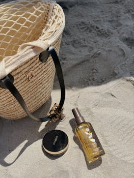 Rattan beach bag with skincare and makeup essentials on sunny sand.