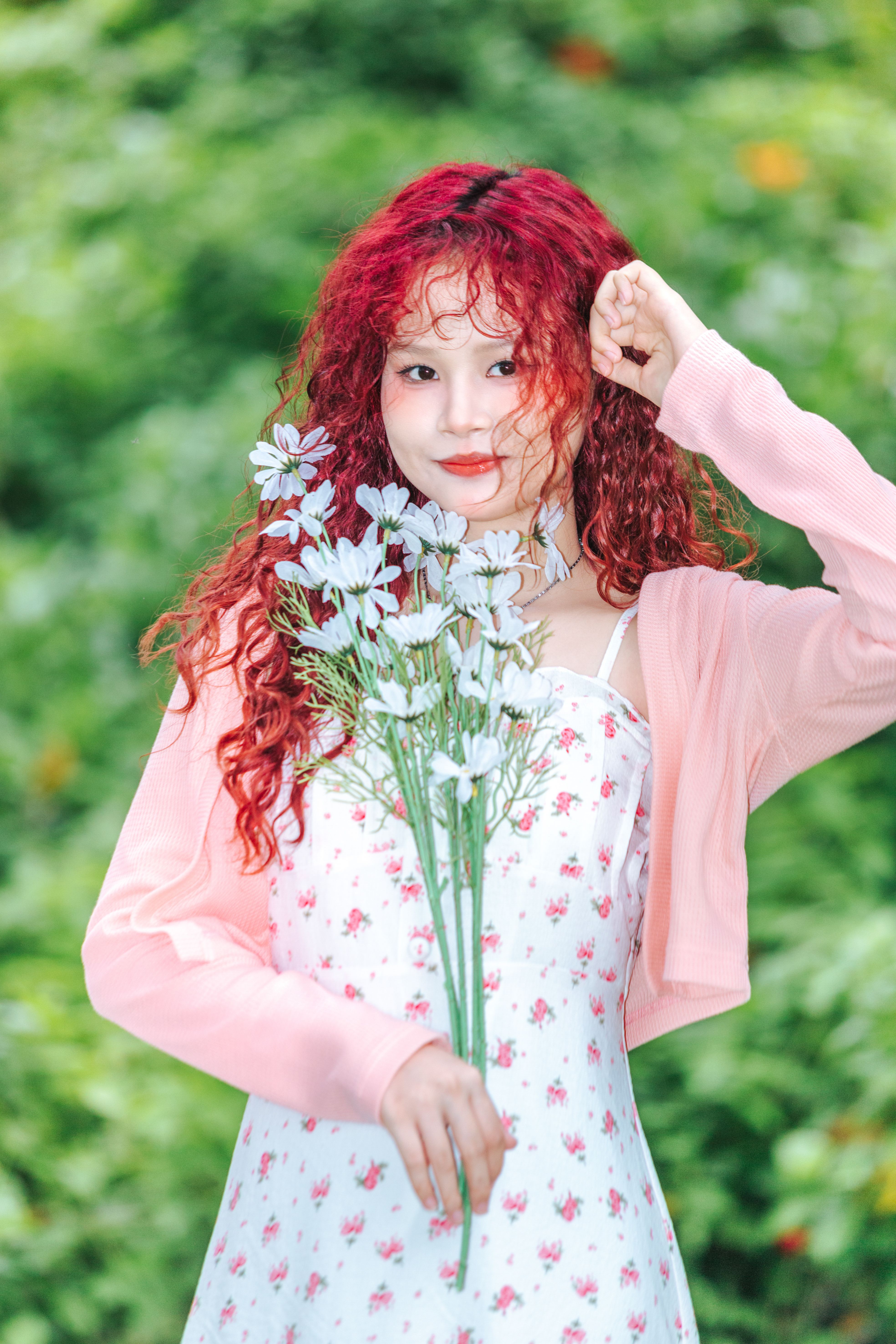 A girl with red hair and flowers in her hand · Free Stock Photo