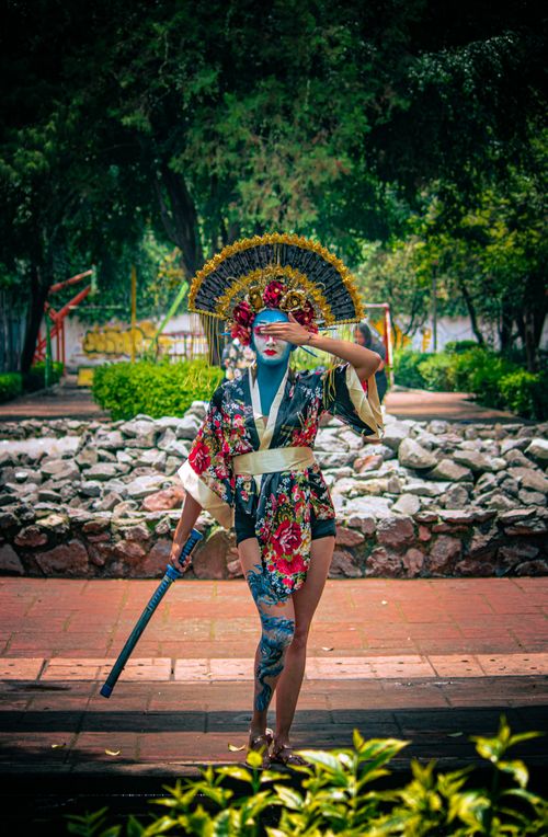 Free Colorful geisha-inspired figure with floral kimono and katana in Mexico City's park scenery. Stock Photo
