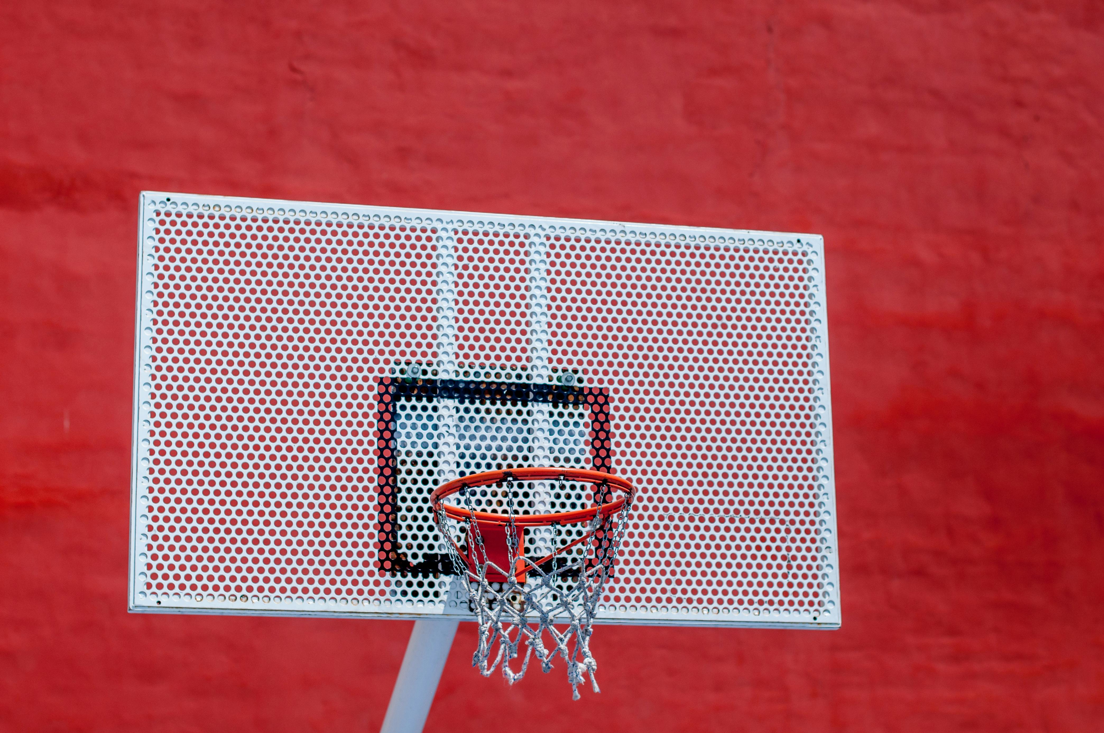 a basketball hoop is on a red wall