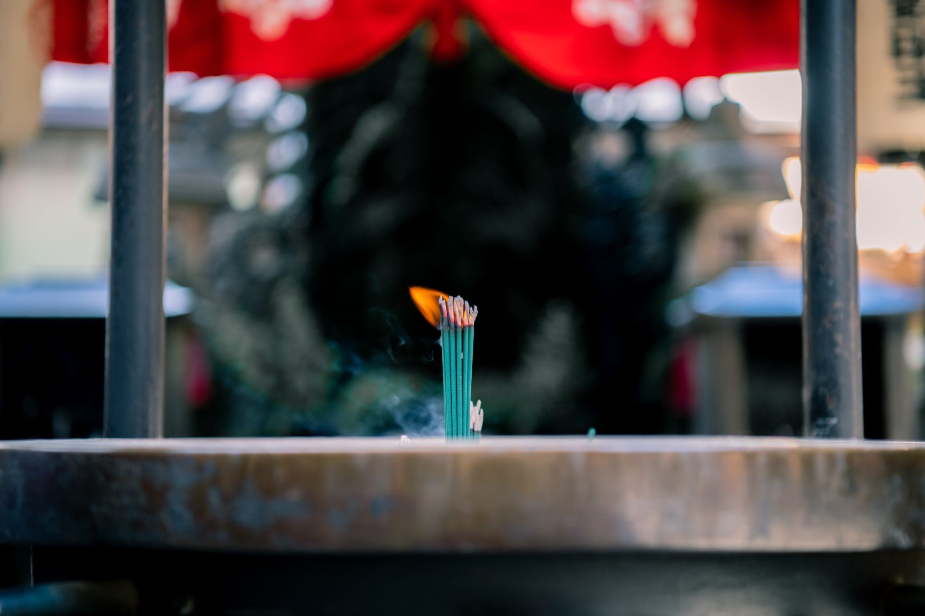 Devotees lighting incense at the four-faced Brahma of the Erawan Shrine