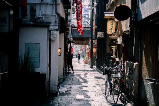在日本大坂的一条狭窄小巷里，设有自行车、步行和传统标志，捕捉了城市街头生活的瞬间