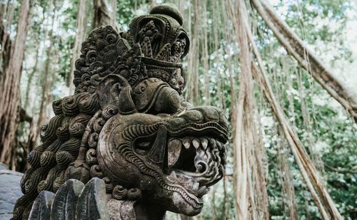 Free A detailed Balinese stone sculpture depicting a mythological creature amidst lush jungle backdrop. Stock Photo