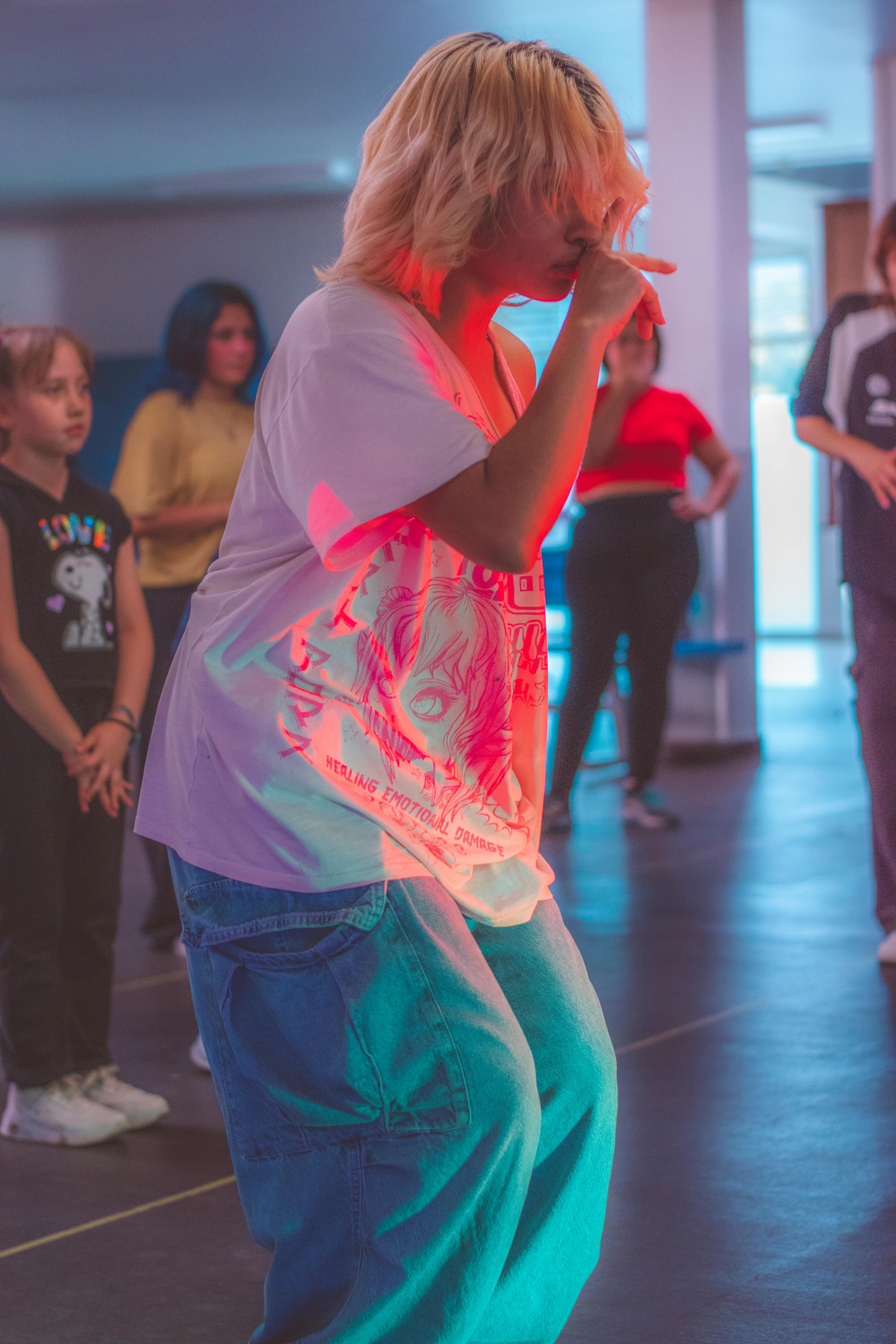 a woman dancing in a dance class with other people