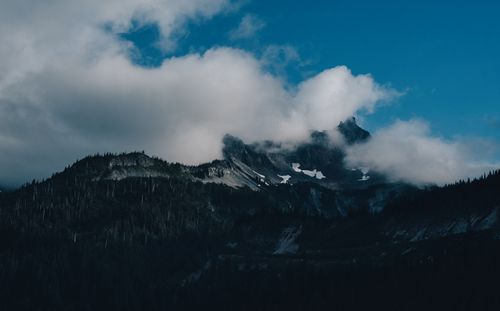 Free Dramatic view of misty mountain peaks shrouded in clouds at sunrise. Stock Photo