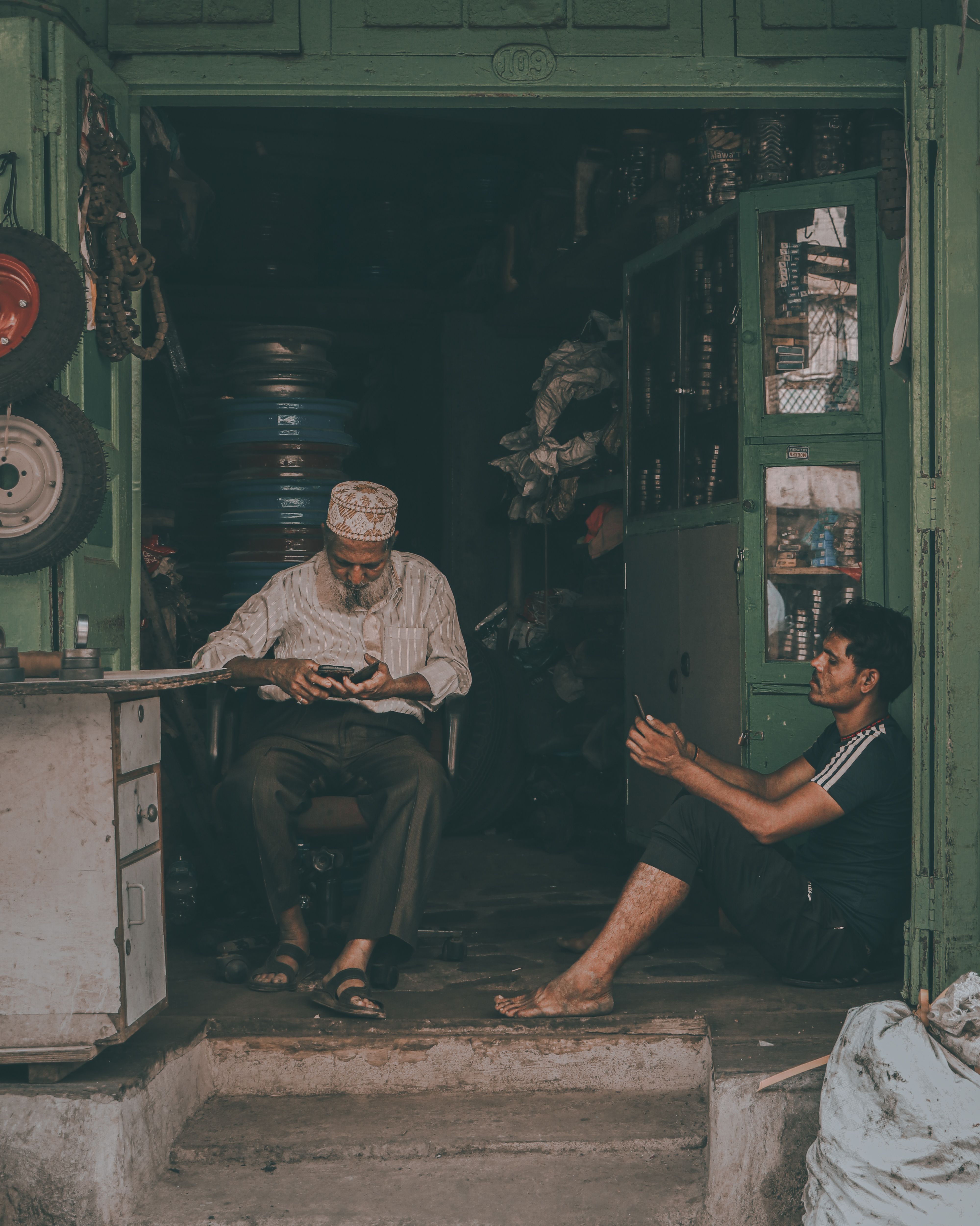 Two men talking inside a cluttered small shop in Mumbai