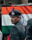 A man in a uniform with an indian flag behind him