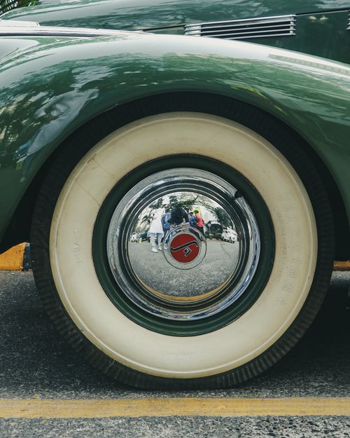 Free Close-up of a vintage car wheel with a chrome hubcap captured on a city street in Mumbai, India. Stock Photo