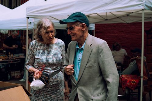 Free Senior couple visiting an outdoor market, enjoying a lively street atmosphere. Stock Photo