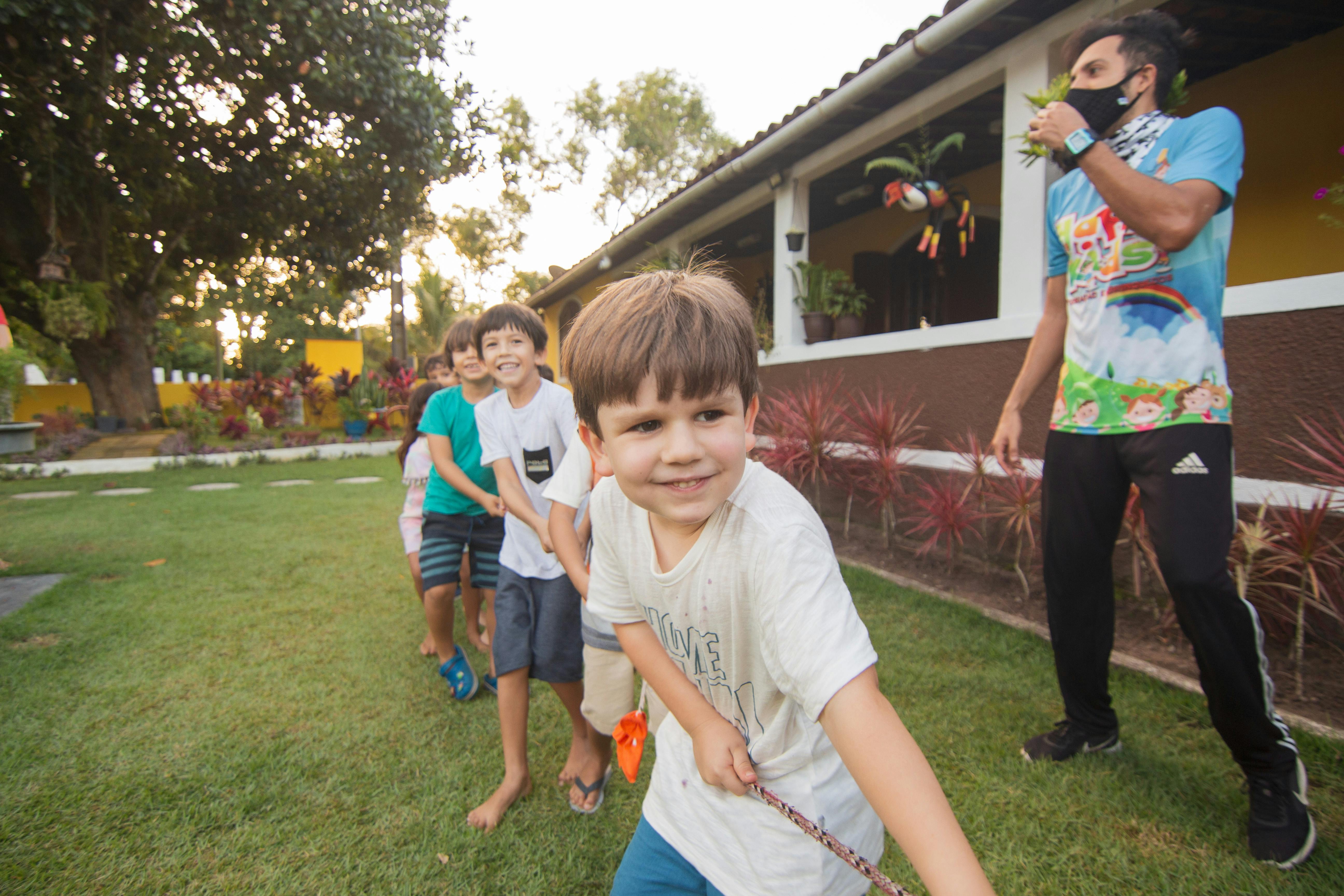 a young boy is holding a stick in the grass