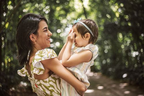 Free A joyful moment of a mother hugging her daughter in a lush green park, capturing love and happiness. Stock Photo
