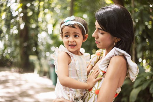 A warm family moment with a mother and daughter in a lush, sun-dappled park setting.