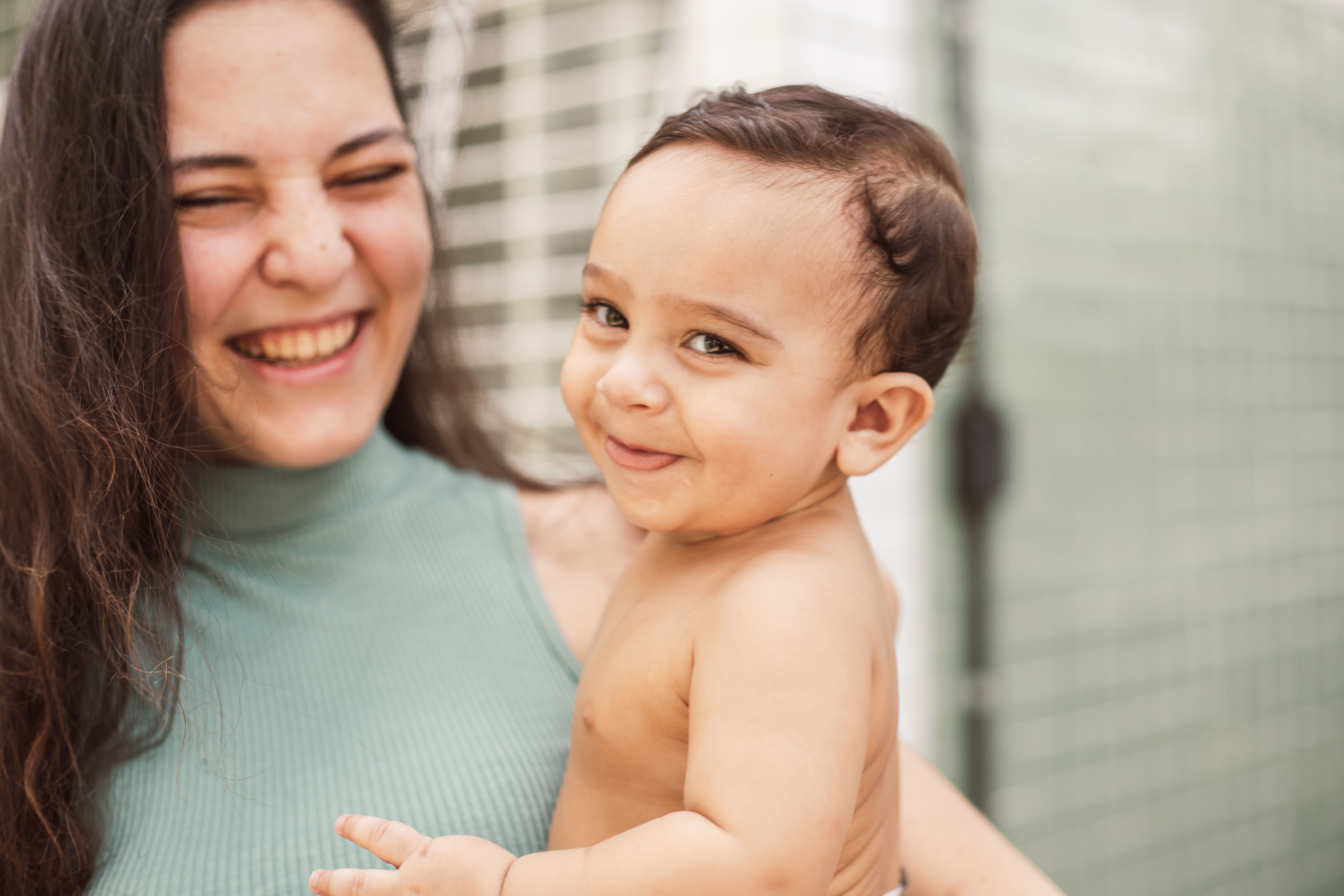 Mãe feliz e confiante segurando bebê sorridente