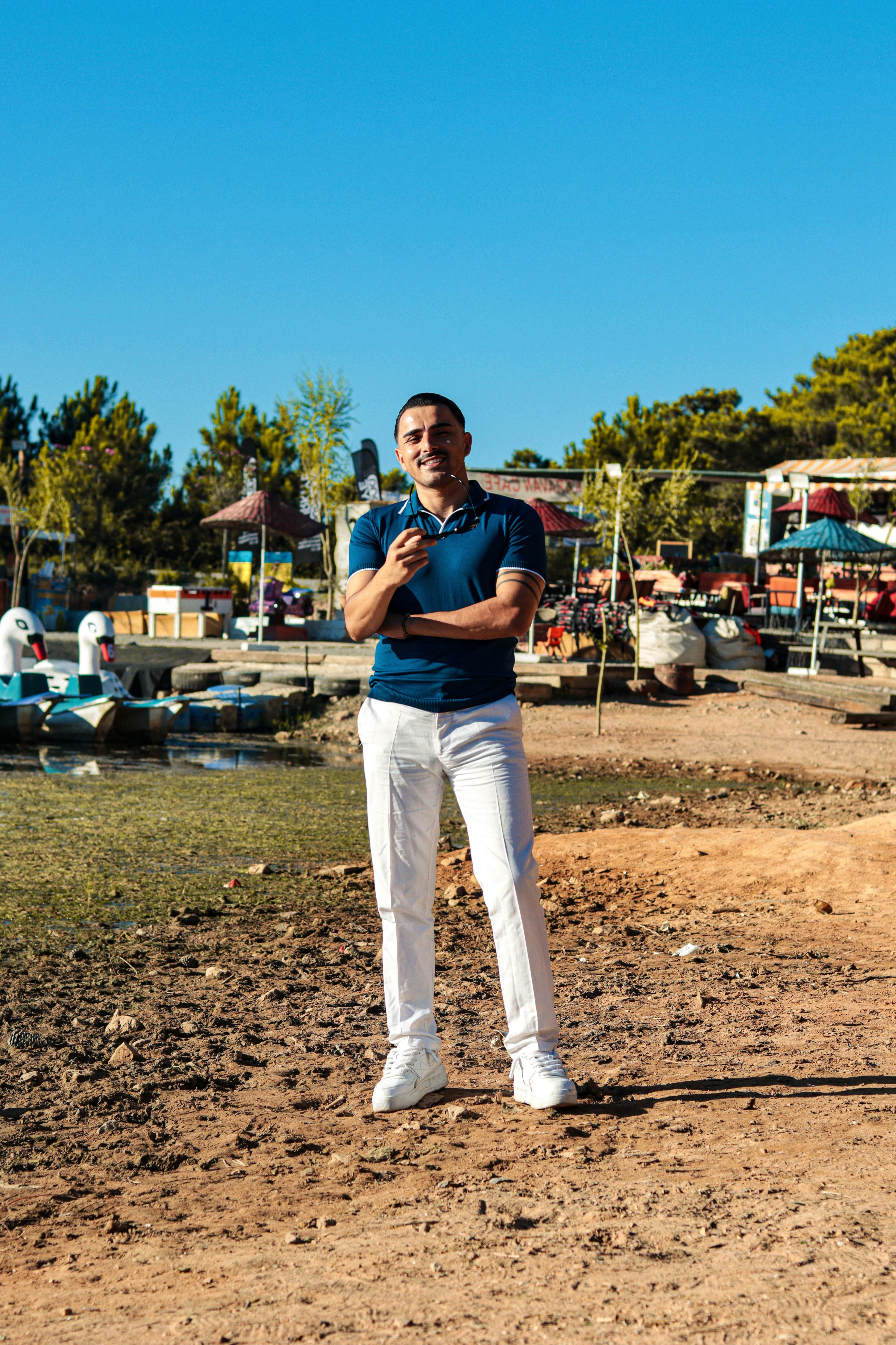 a man standing on a dock in front of a lake