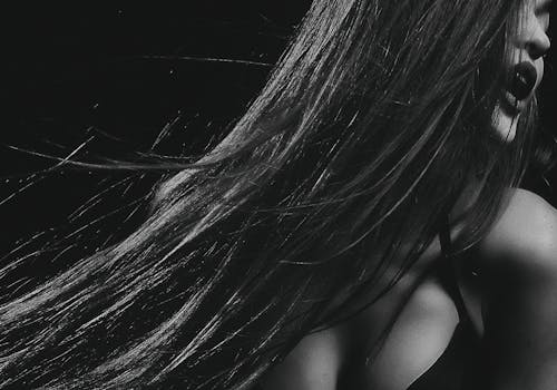 Elegant black and white portrait capturing movement with flowing hair and striking contrast.