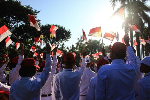 Free Crowd celebrating with Indonesian flags outdoors in Jakarta. Stock Photo