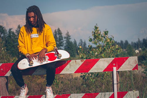 Photo Of Man Holding Skateboard 