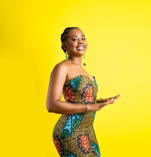 Free Bright portrait of an African woman in a colorful dress and jewelry, smiling confidently. Stock Photo