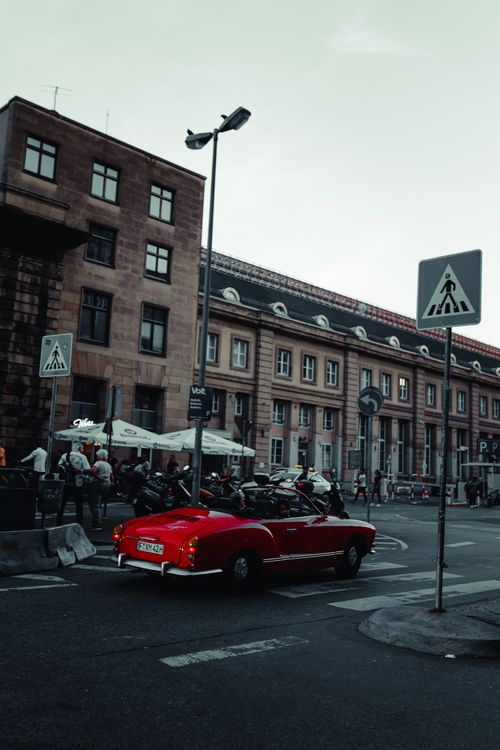 Free A timeless red car drives through the historic streets of Frankfurt, Germany. Stock Photo