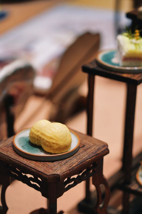 Free A beautifully presented dessert on ornate wooden stands, adding elegance to a dining setup. Stock Photo