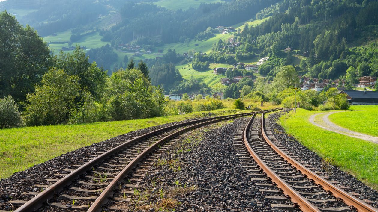 A train track running through a green field · Free Stock Photo