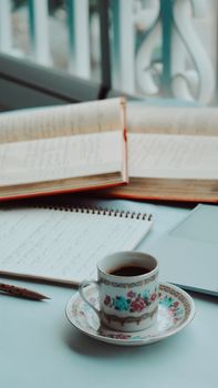 A serene workspace with coffee, open books, and notebook for productive mornings.