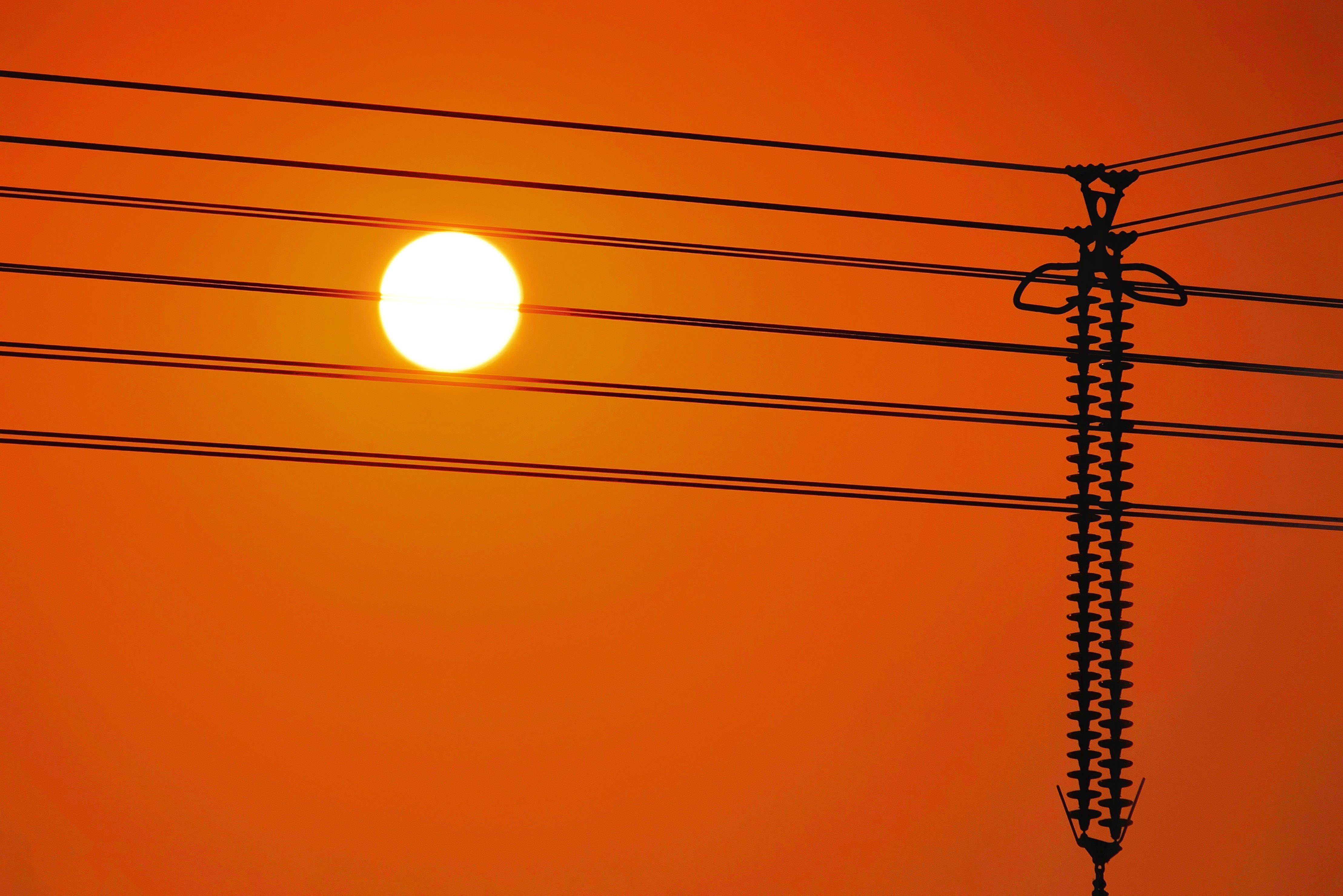 Vivid orange sunset with silhouette of power lines in Ho Chi Minh City, Vietnam.