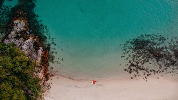 A stunning aerial view of a tropical beach with turquoise waters and coral reef in Colombia.
