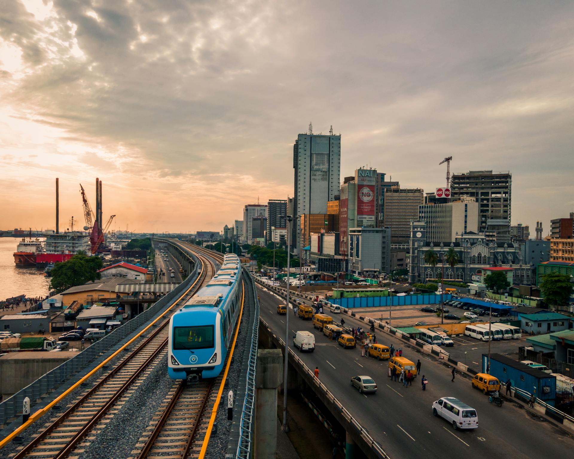 Aerial view of a train passing through Lagos, highlighting the city's urban skyline and bustling transport systems.