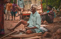 在印度埃鲁鲁一条繁忙的街道上，一位老人坐着兜售工艺品