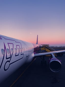 Close-up of a commercial airplane at an airport during a serene sunset, showcasing aviation technology.