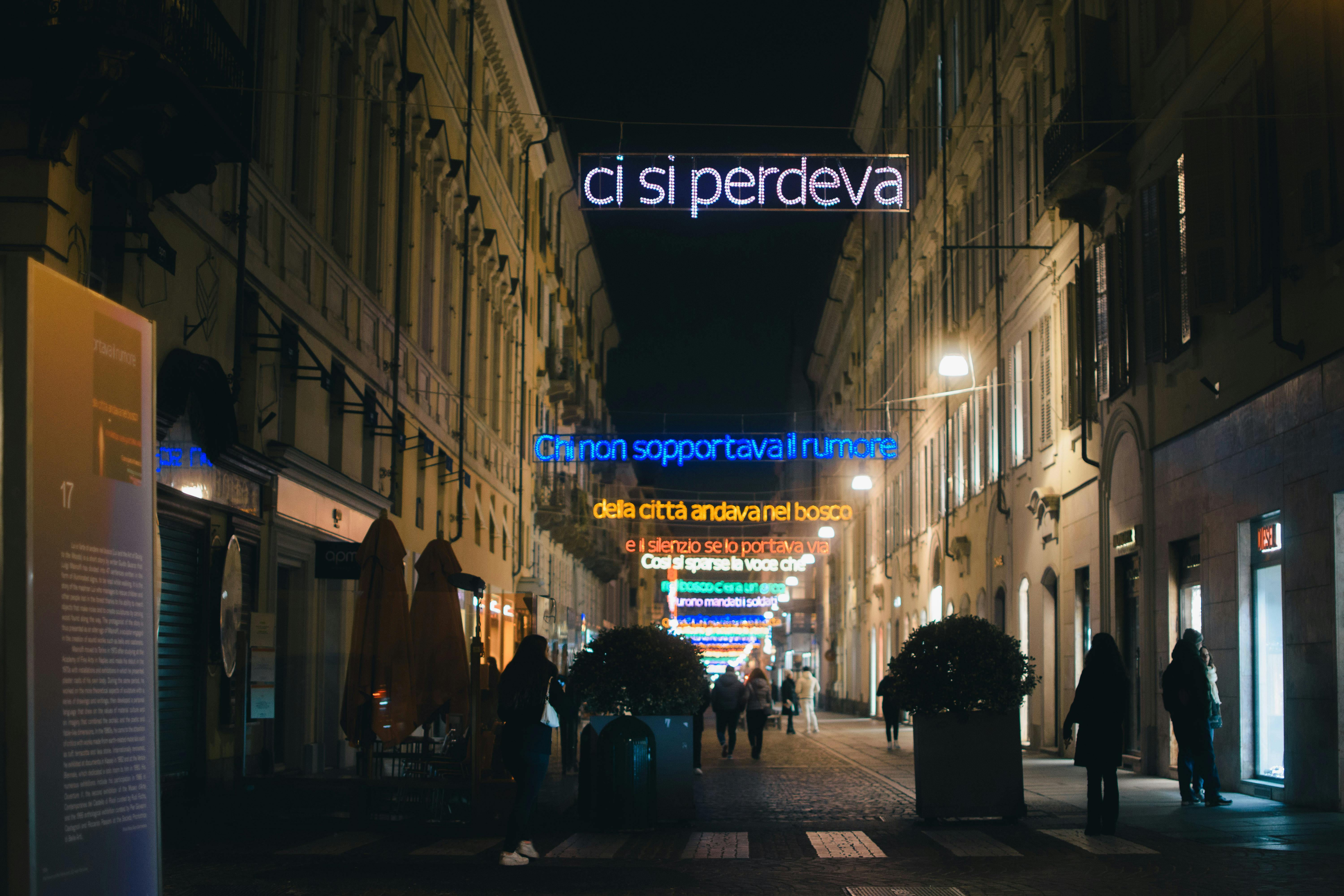 a street with people walking down it at night