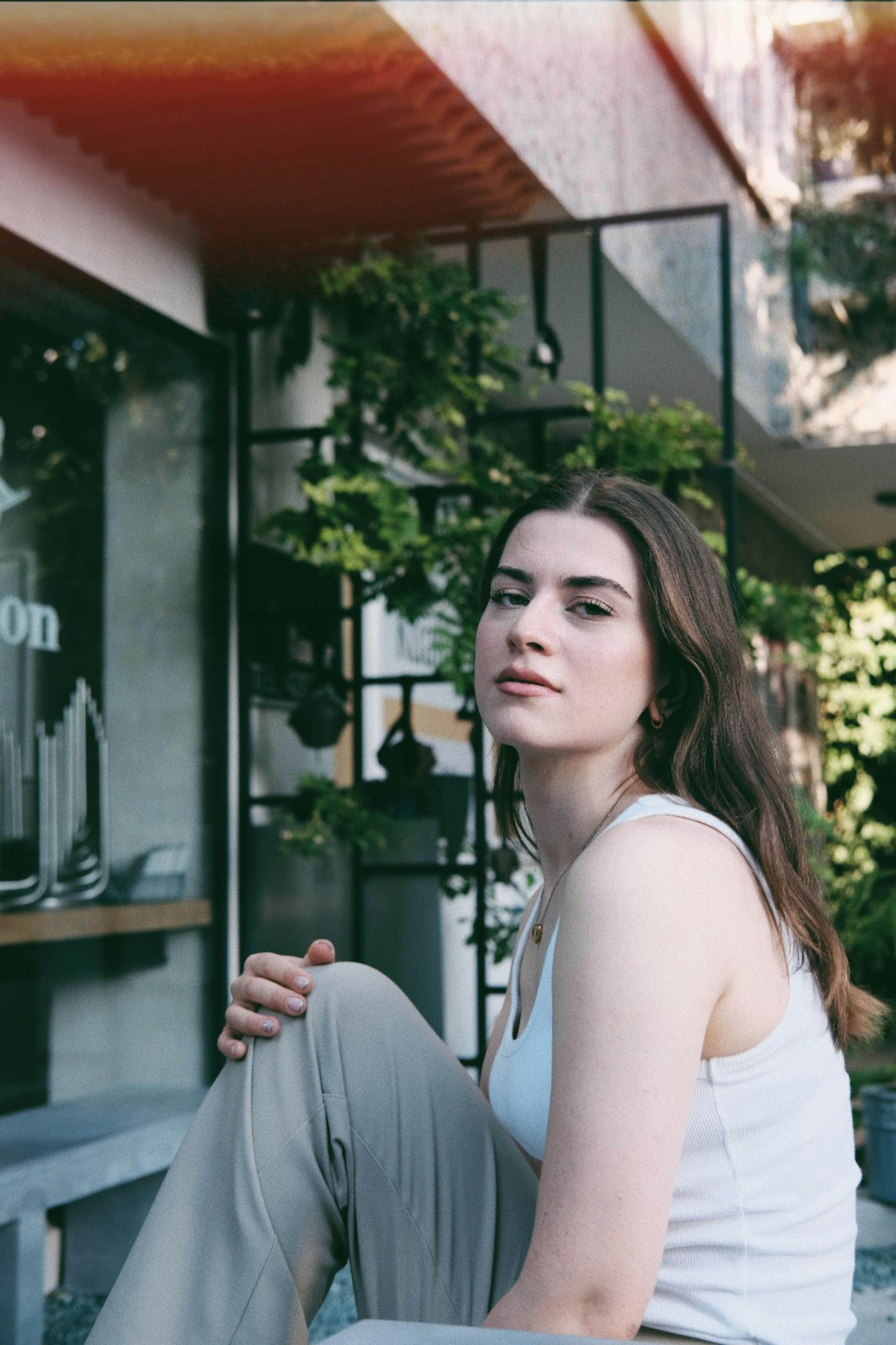 Elegant woman in a relaxed pose enjoying leisure time outdoors in a summer setting.