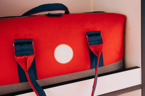 Close view of a red panel bag with woven navy straps — photo by Mikhail Nilov on Pexels