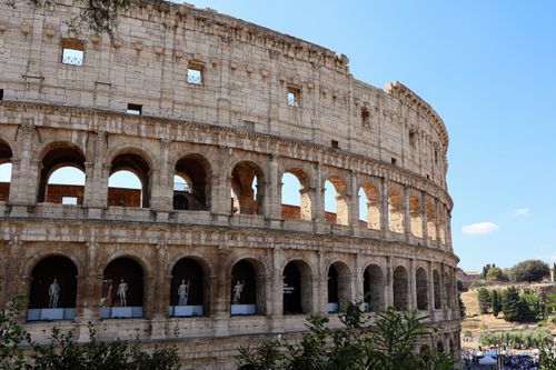 Free Close-up of the Colosseum's arched facade in Rome with clear blue sky. Stock Photo