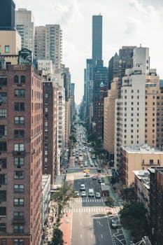 A vibrant aerial view of a busy street in New York City lined with skyscrapers and bustling with traffic.