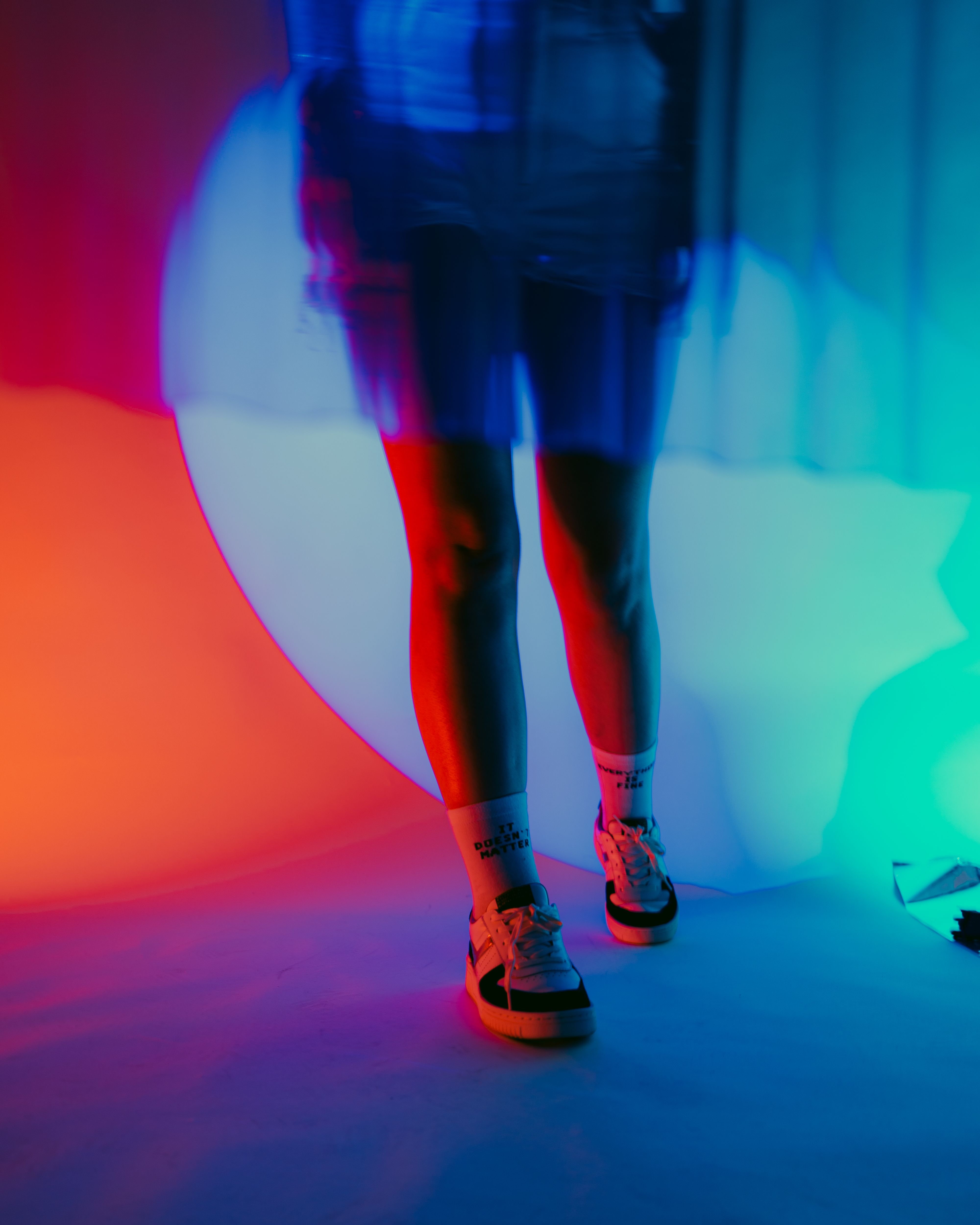 A woman standing in front of a colorful light · Free Stock Photo